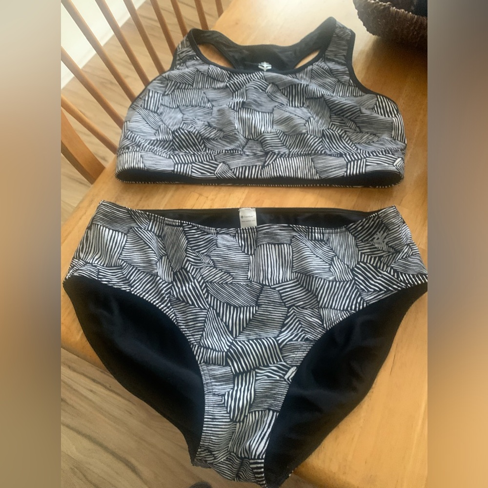 Two piece.. so cute!! Top is more like a sports bra. Adorable! Black and white.